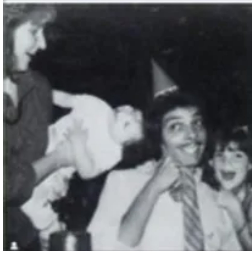 Black and white photo with people wearing party hats 