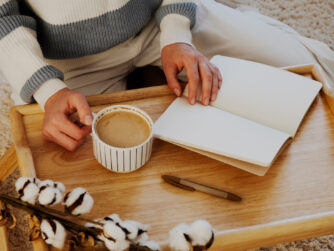 Woman with blank notebook and cup of coffee