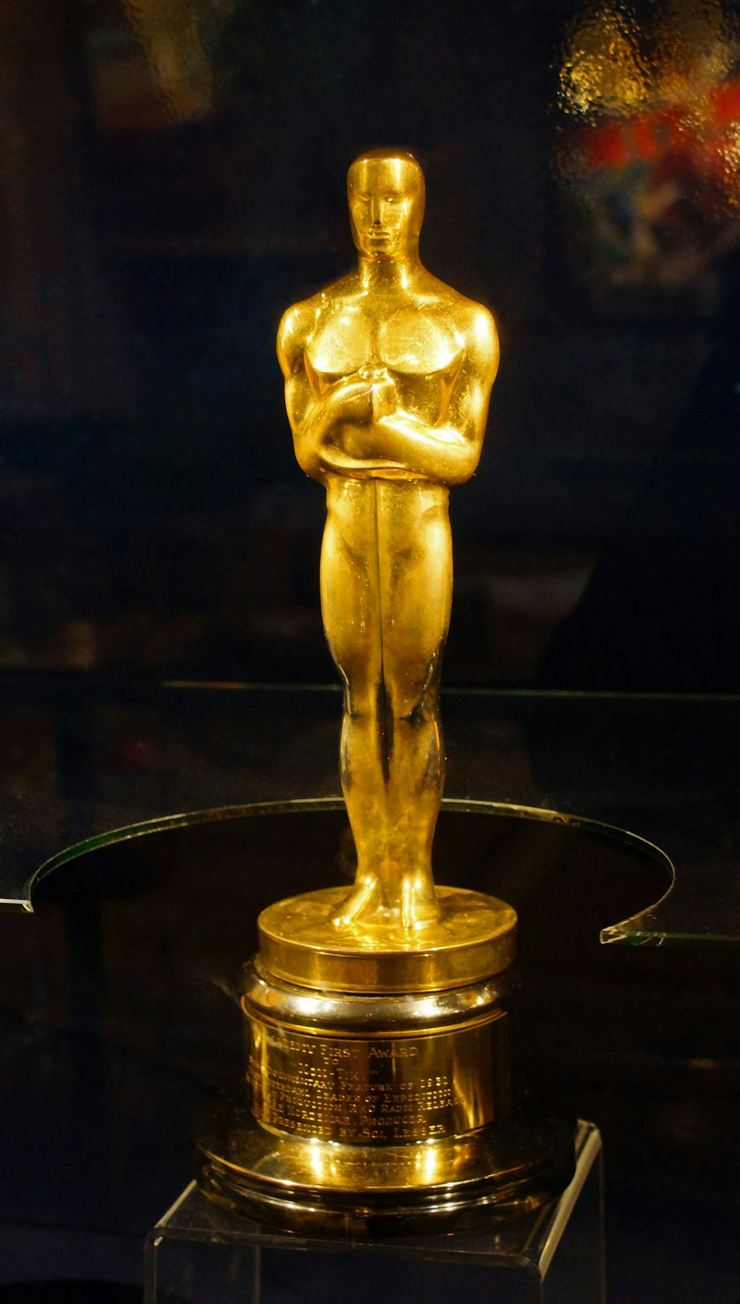 An oscar statue on display in a glass case An oscar statue on display in a glass case